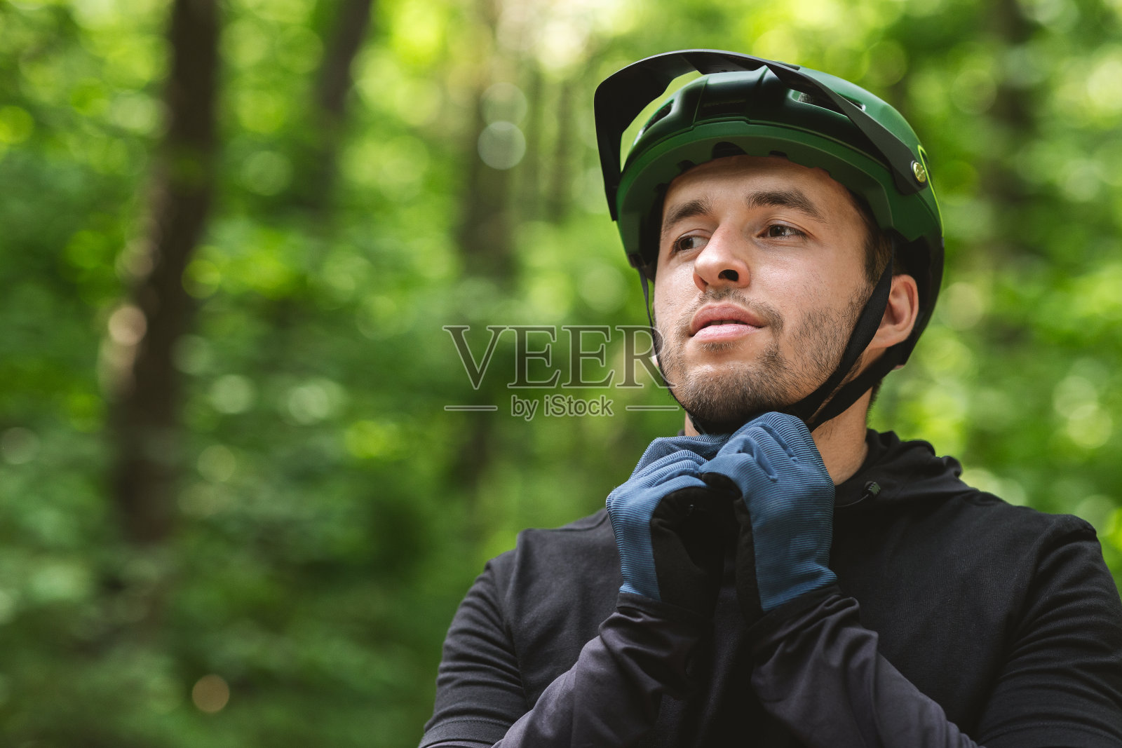 骑自行车前戴上头盔的英俊男子照片摄影图片
