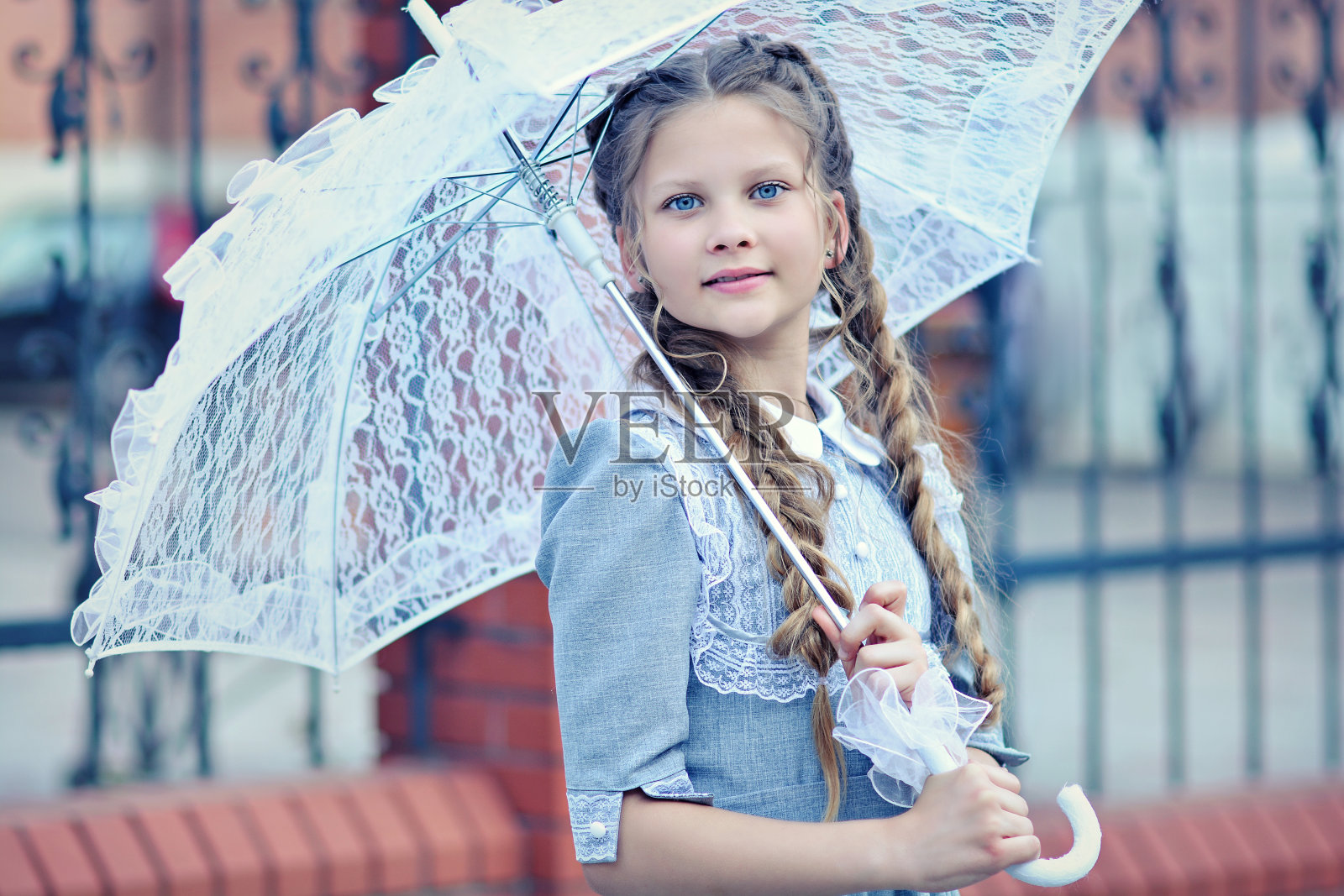 一个美丽的女孩的肖像在复古的裙子和复古的雨伞在她的手照片摄影图片