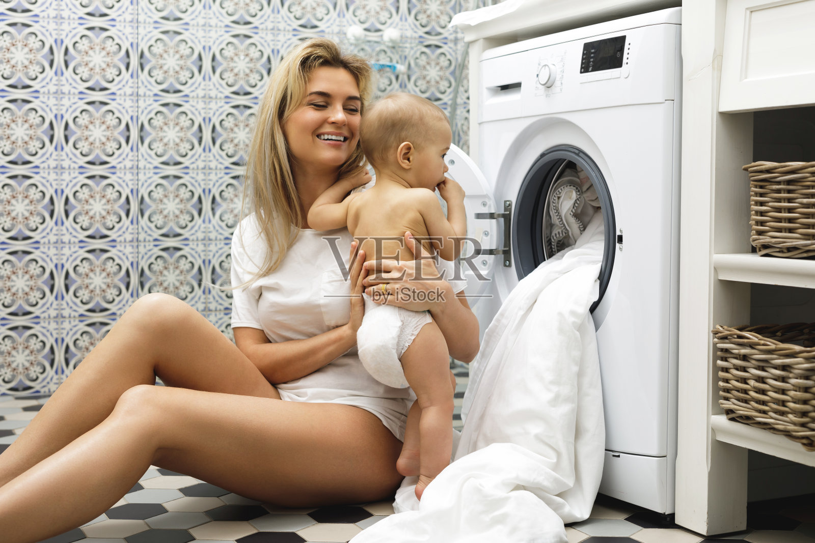 母亲和她的小儿子正在装洗衣机照片摄影图片