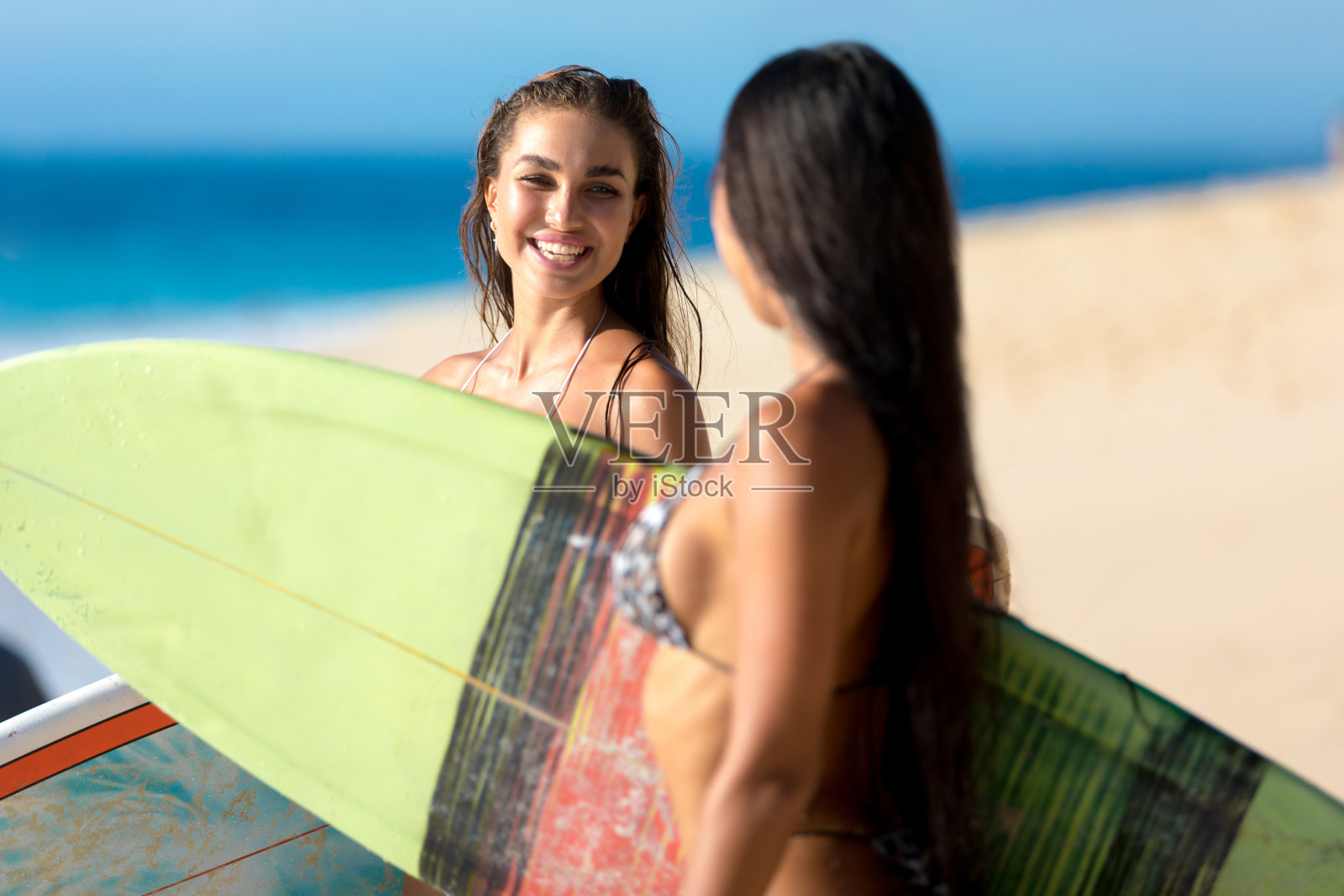 两个女人在海滩冲浪照片摄影图片