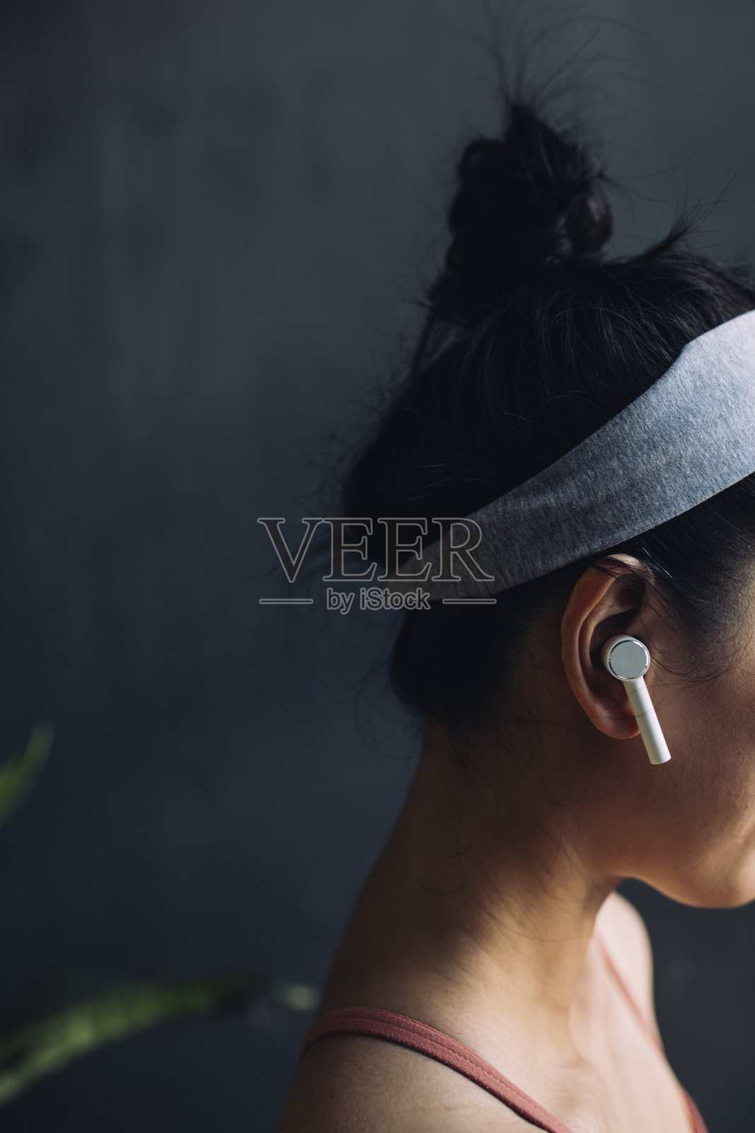 一个准备开始瑜伽练习的女人耳朵里的无线耳机照片摄影图片