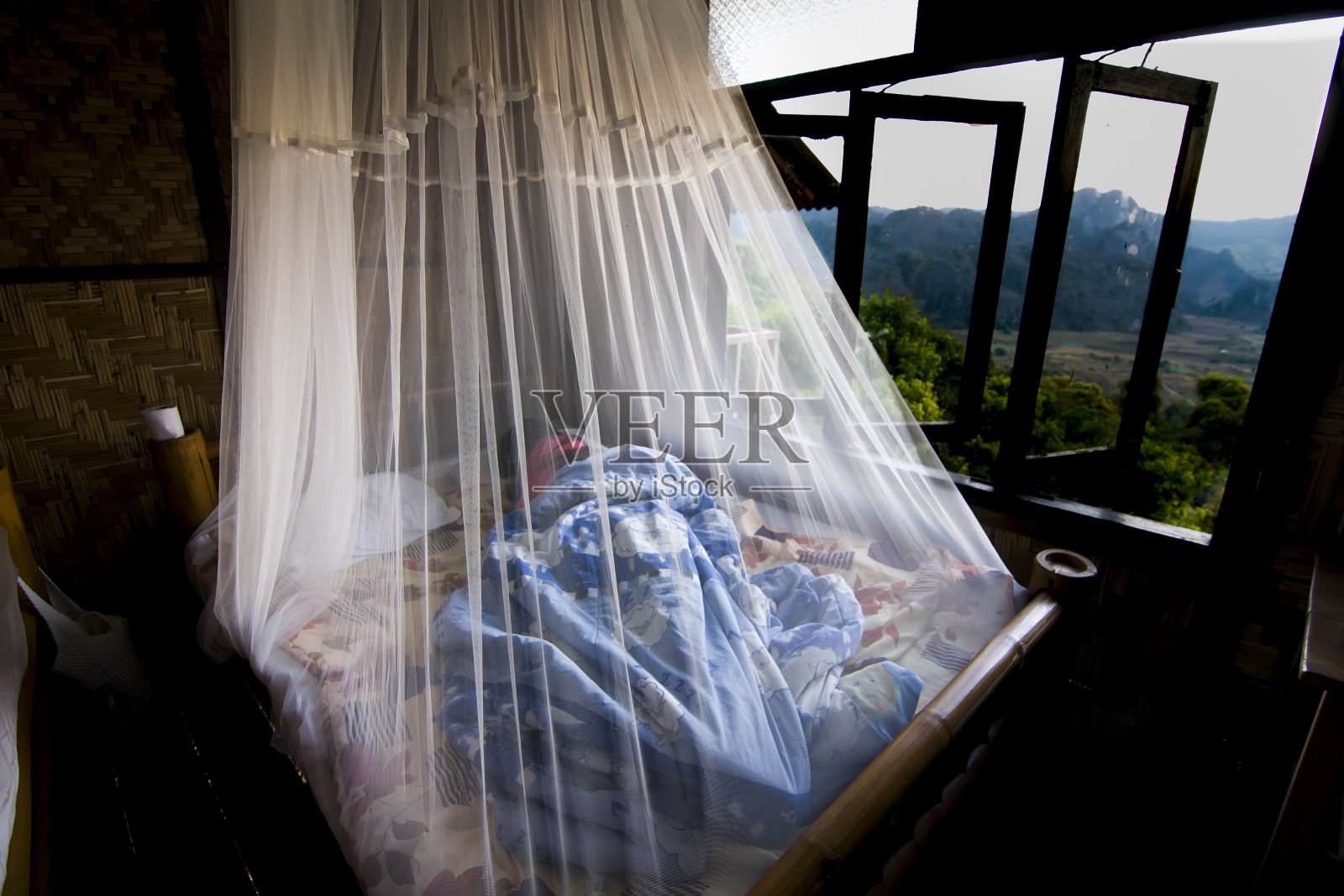 漂亮女人睡在蚊帐里以防蚊子。照片摄影图片