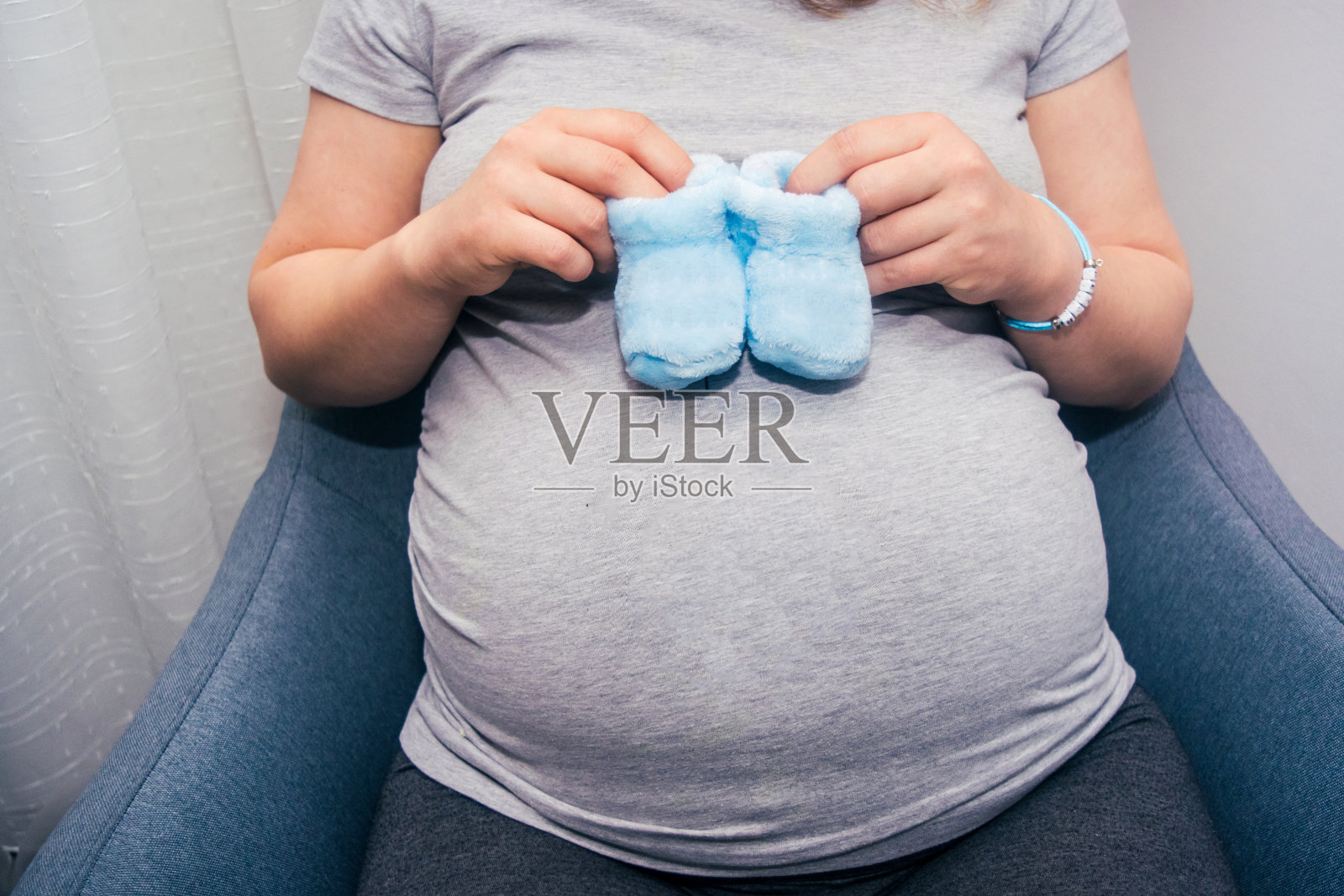 孕妇的肚子与新生婴儿的靴子库存照片照片摄影图片