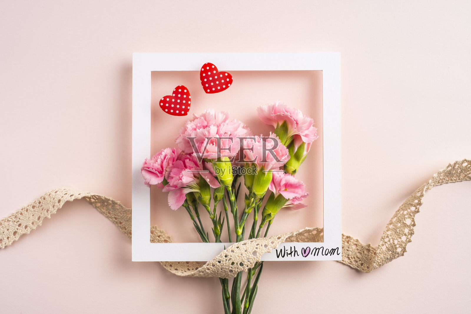 俯视图的康乃馨与卡片在粉红色的背景照片摄影图片
