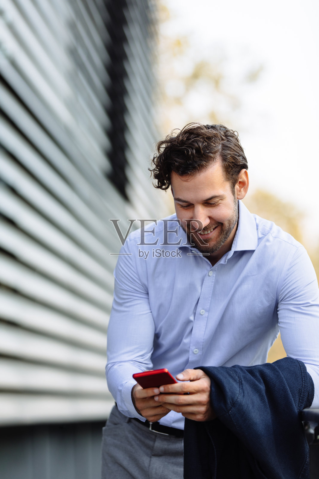 一个商人使用手机和短信的肖像照片摄影图片