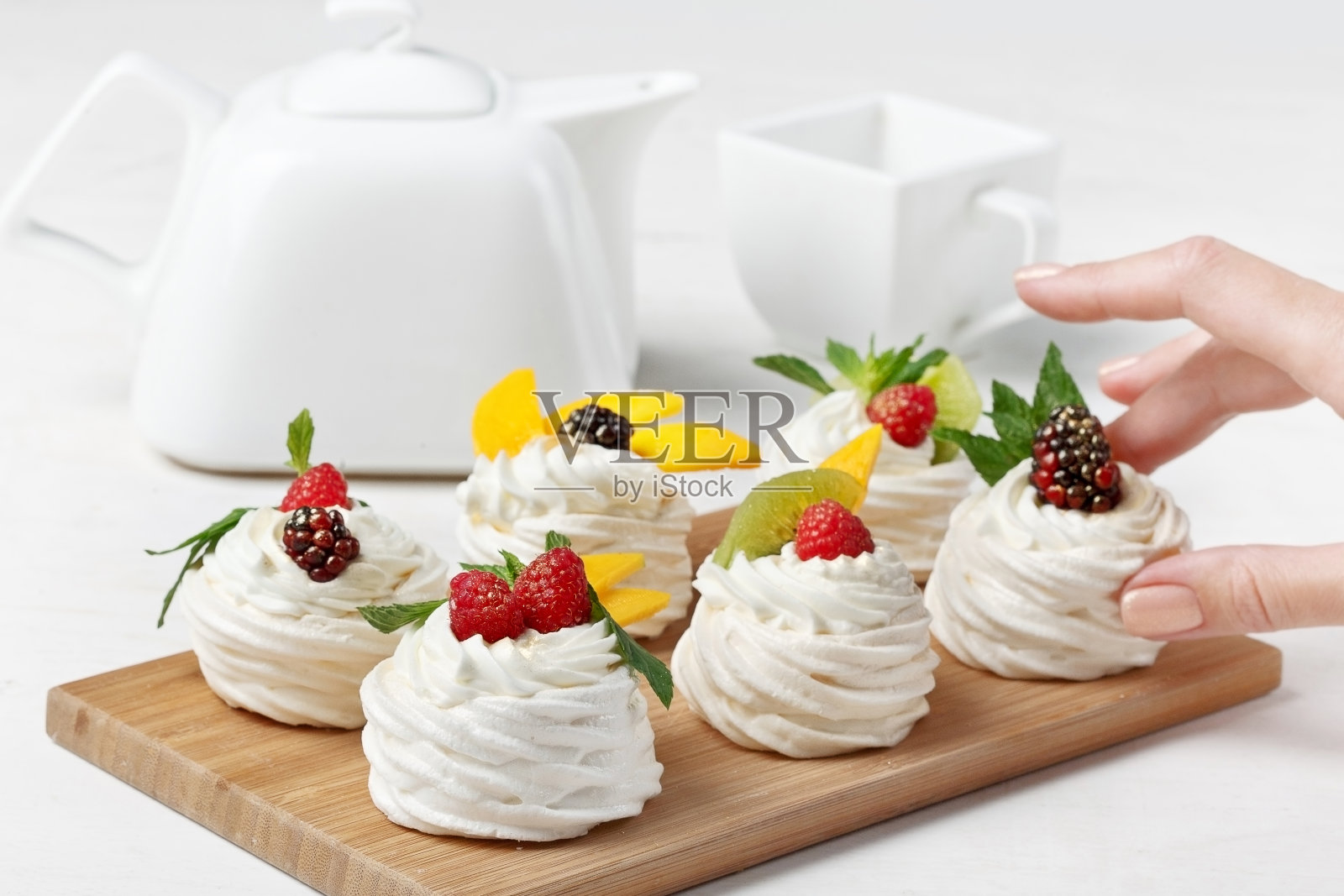 自制的迷你巴芙洛娃蛋糕配上鲜奶油和新鲜浆果。有选择性的重点。照片摄影图片