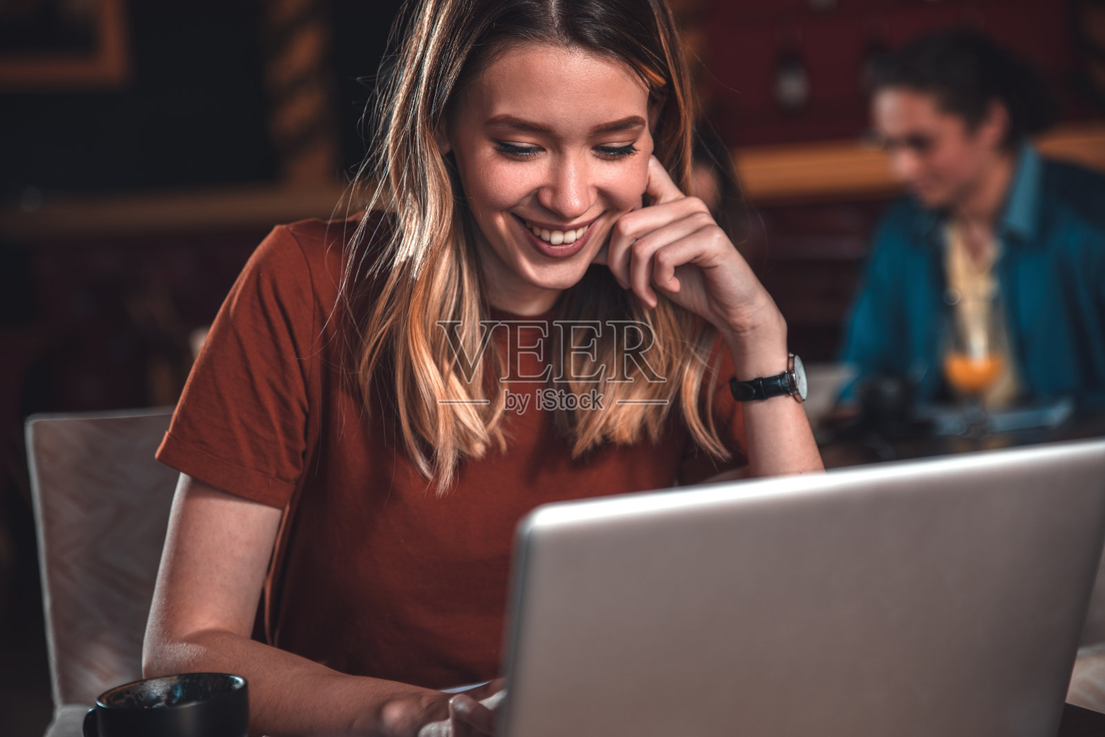 年轻女学生坐在咖啡馆里用笔记本电脑做下一个项目。照片摄影图片