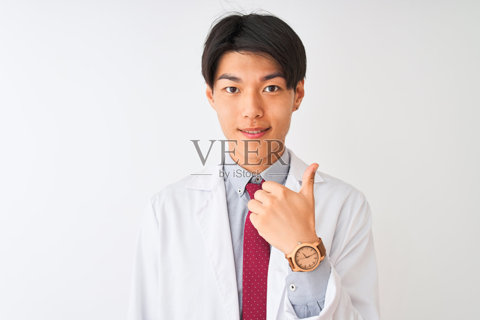 中国科学家戴着领带，穿着外套，站在孤立的白色背景下做着高兴的竖起大拇指的手势。赞许的表情看着镜头，表示成功。照片摄影图片
