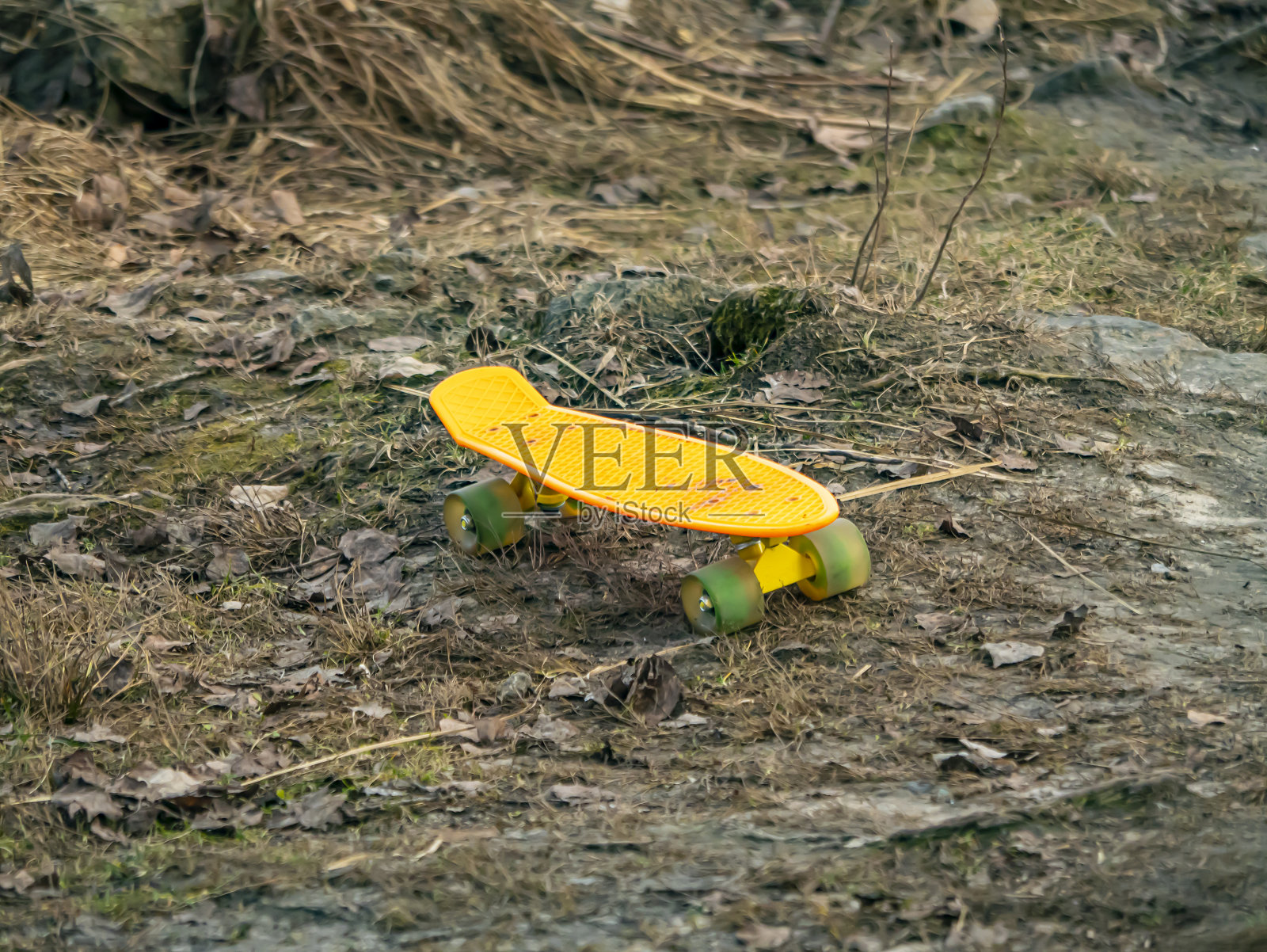 在地上骑的黄色滑板。照片摄影图片