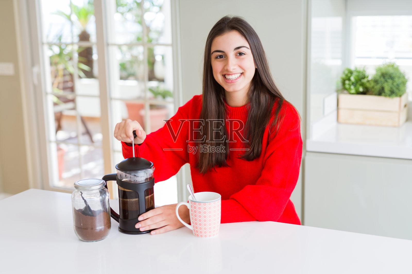 年轻漂亮的女人微笑着做早上的咖啡，准备一杯拿铁早餐照片摄影图片
