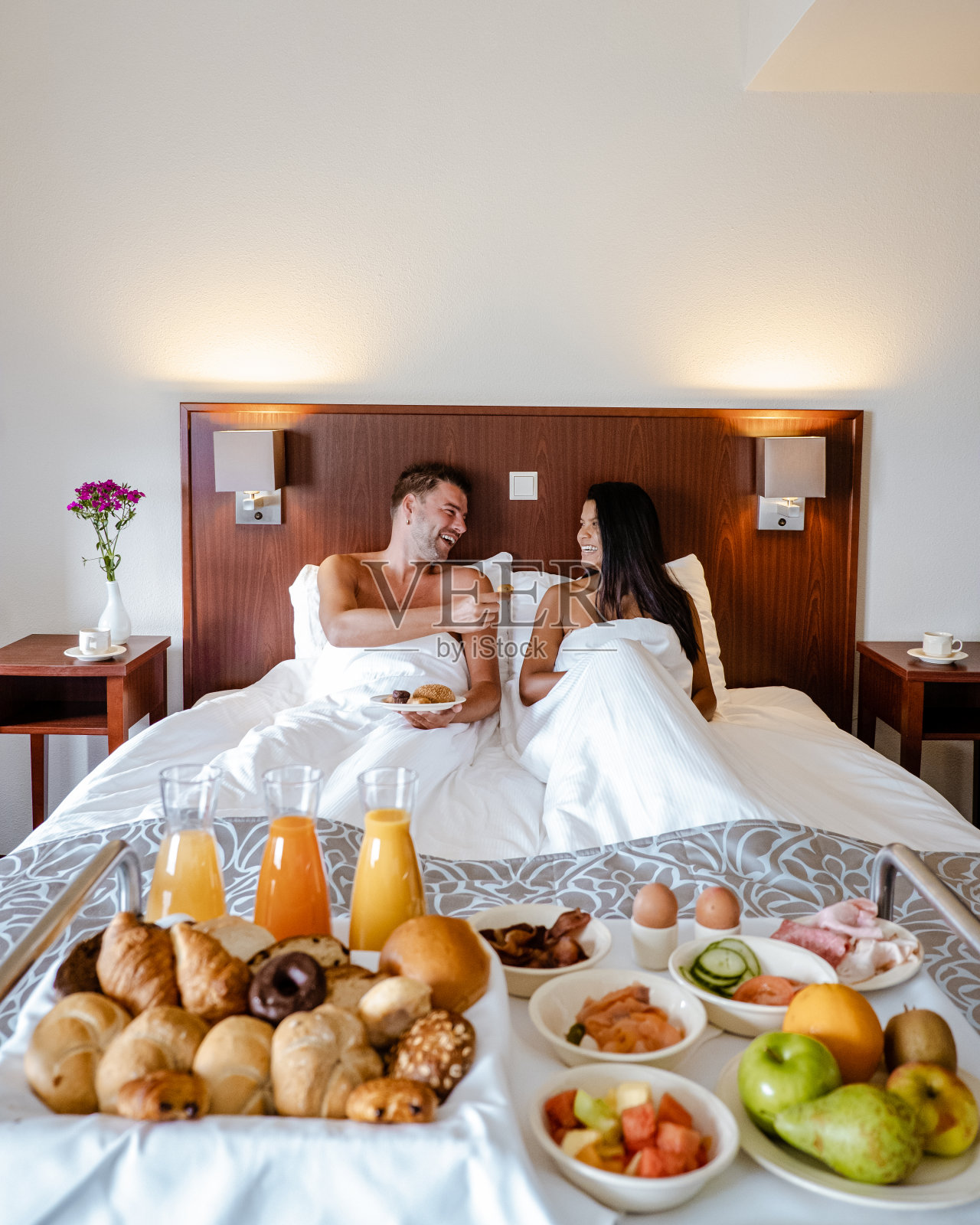 早餐在床上，夫妇在床上喝咖啡在一个豪华酒店的房间照片摄影图片