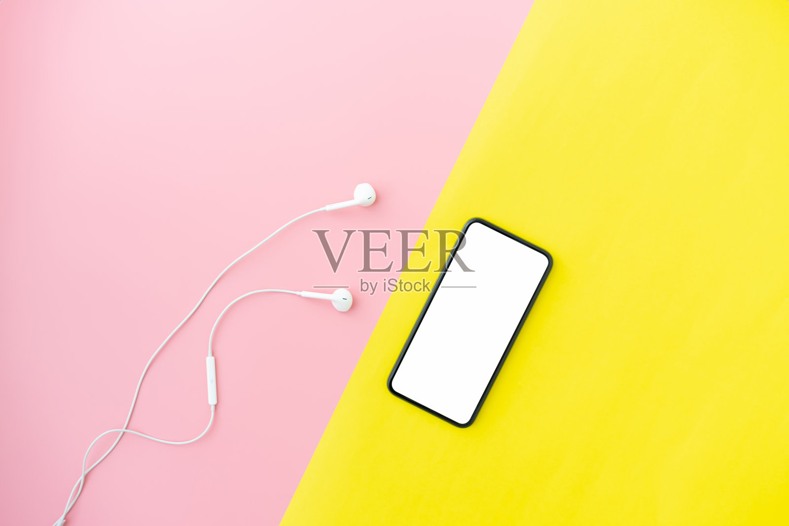俯视图的现代智能手机和白色耳机上的粉红色与黄色背景。照片摄影图片