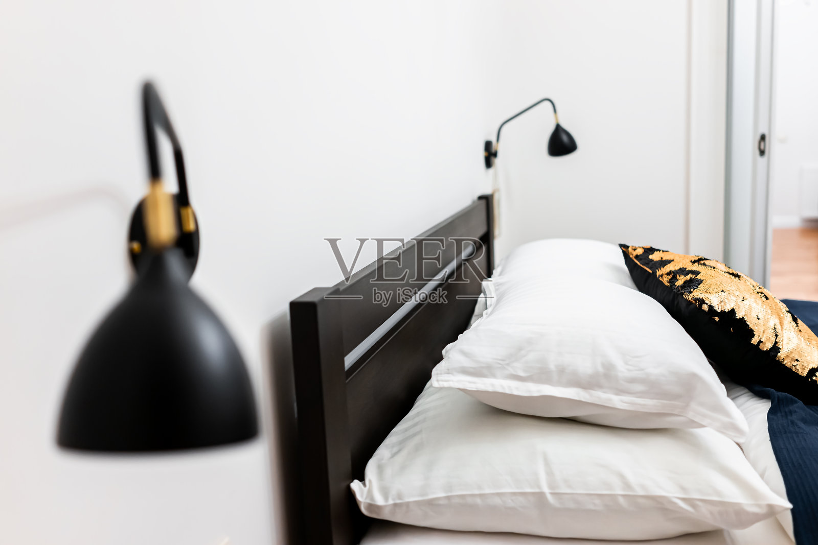 新干净的皇后床与壁挂灯灯，装饰枕头在卧室的家，房子或酒店公寓的侧视图特写照片摄影图片