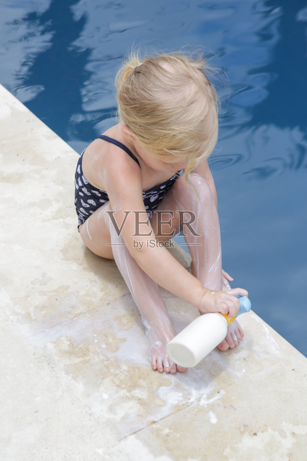 可爱的小女孩正在涂防晒霜。暑假期间保护宝宝不受阳光伤害的防晒乳液。旅行期间的儿童保健和皮肤护理。照片摄影图片