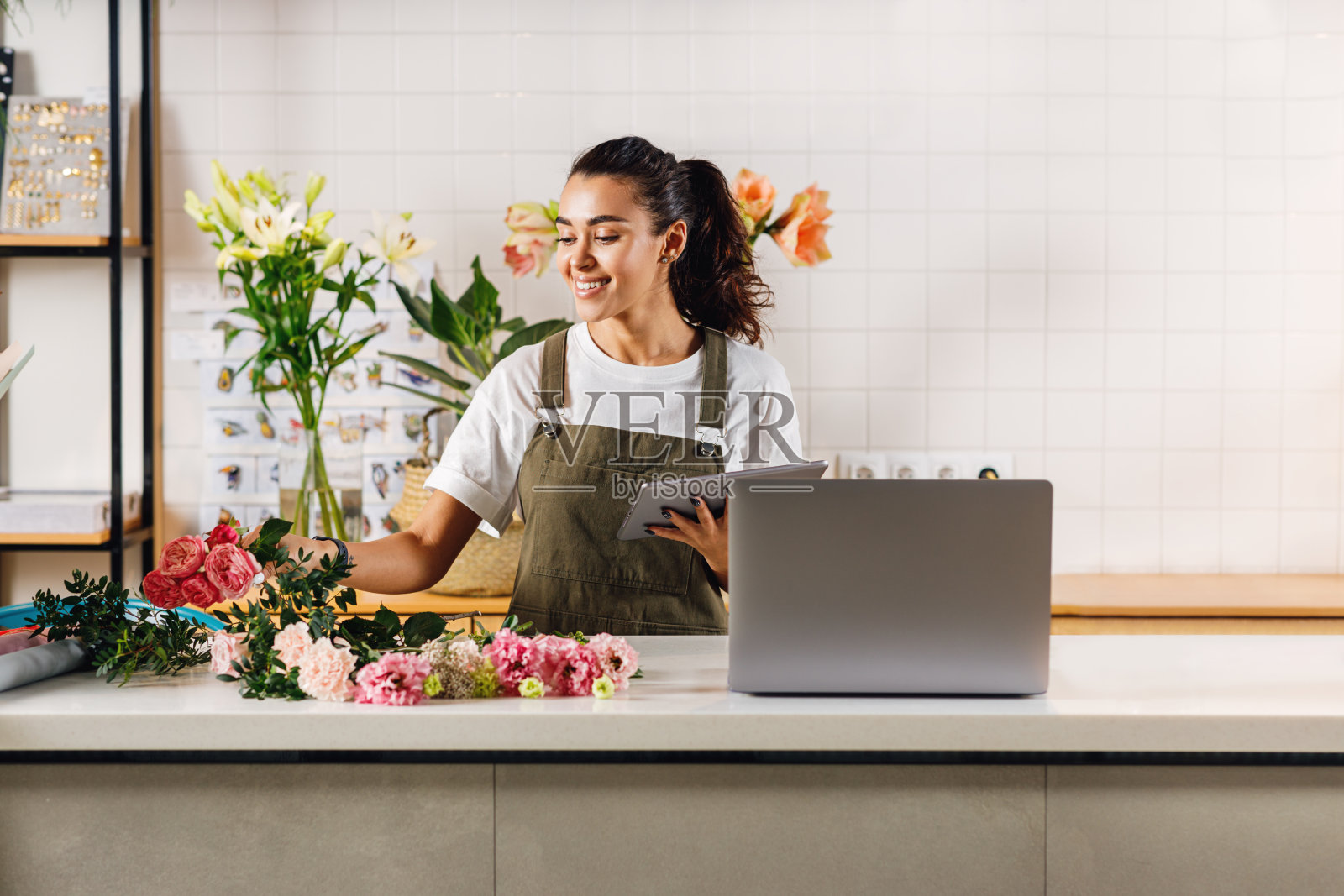 手持平板电脑的女子正在挑选花束照片摄影图片