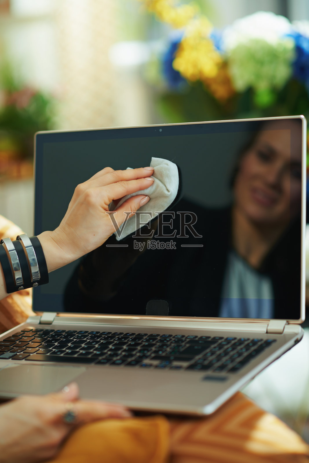 微笑的女人用清洁布清洁笔记本电脑照片摄影图片