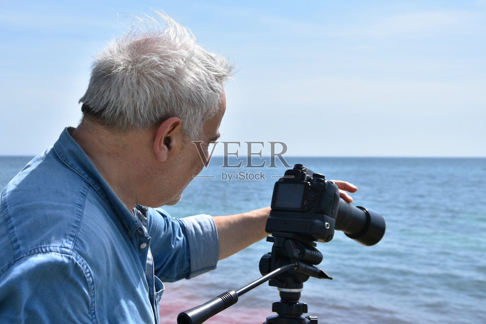 海边一位老年摄影师的肖像照片摄影图片