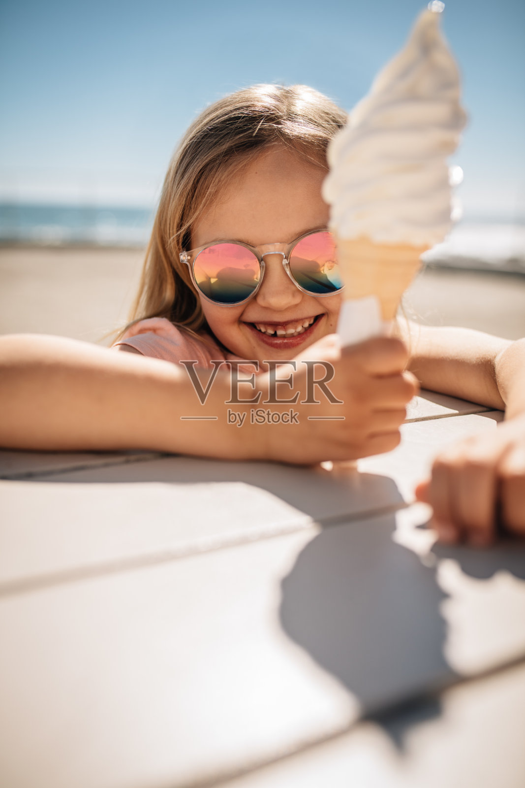 可爱的女孩在海滩上吃冰淇淋照片摄影图片
