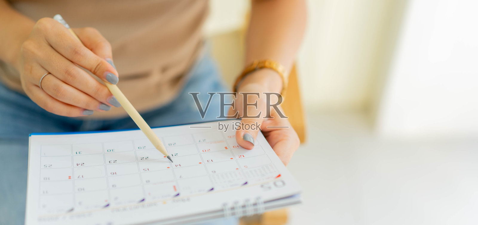 近距离高级员工女性手用钢笔写时间表，在日历上做预约会议或管理时间表，每天在家工作的概念照片摄影图片