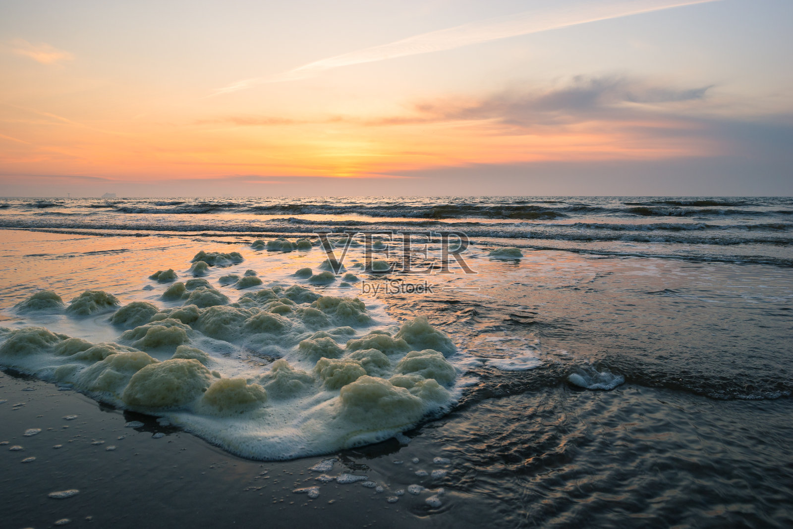 日落时海滩上的浪花照片摄影图片