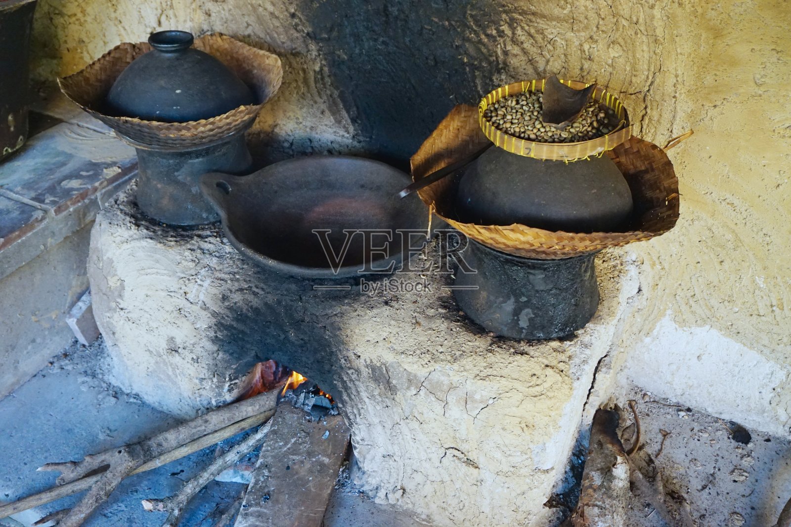 印尼巴厘岛的乡村咖啡烘焙设备，配有木制烤炉和煤烟污迹斑斑的陶罐照片摄影图片