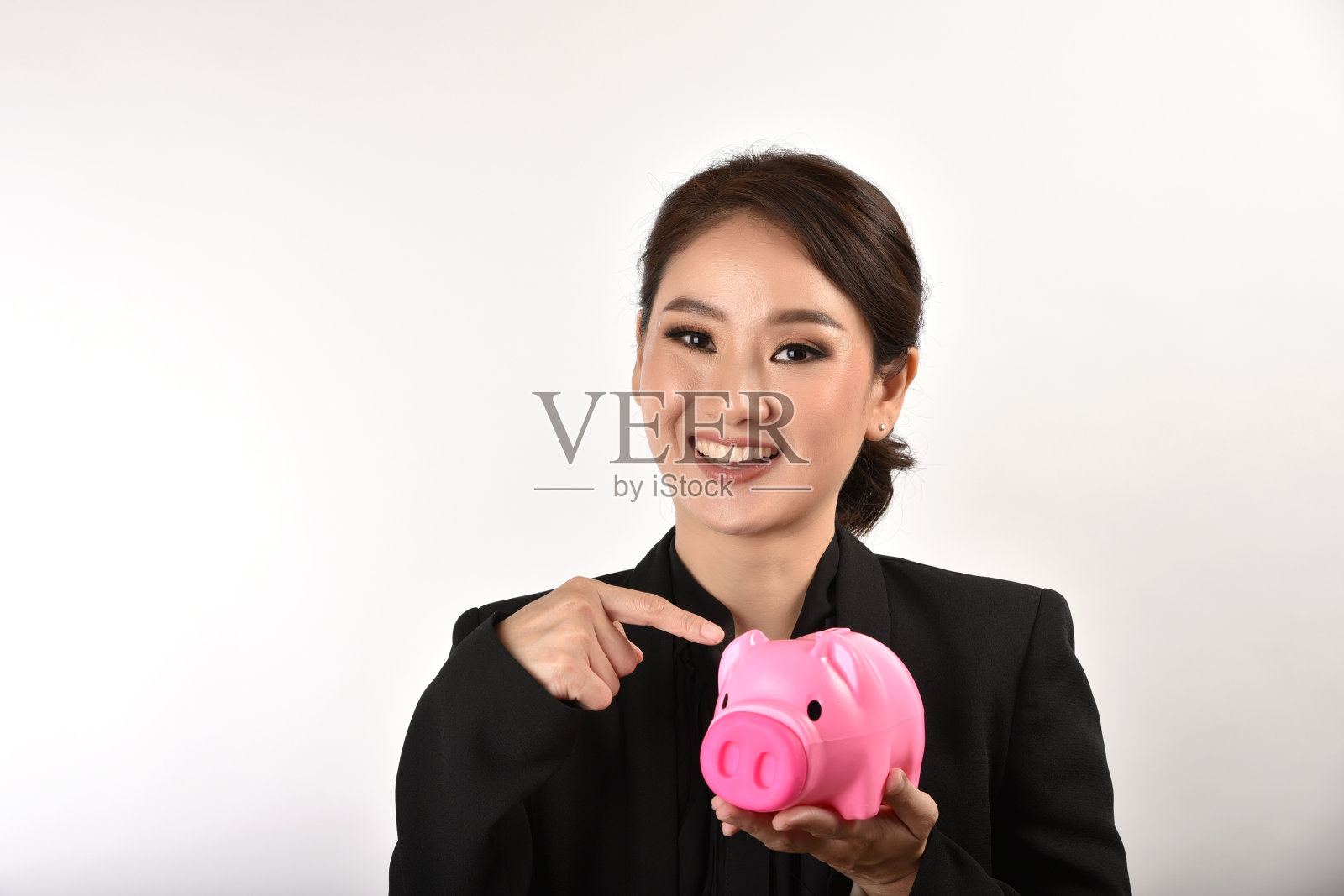 理财顾问存钱专家，亚洲商业女性微笑着拿着粉色的存钱罐，财富和投资理财计划保险。照片摄影图片