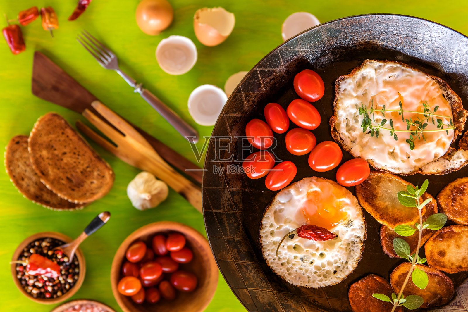 早餐是煎蛋、樱桃番茄和面包。炸土豆和西红柿。减肥食品。乡村早餐配新鲜鸡蛋。照片摄影图片