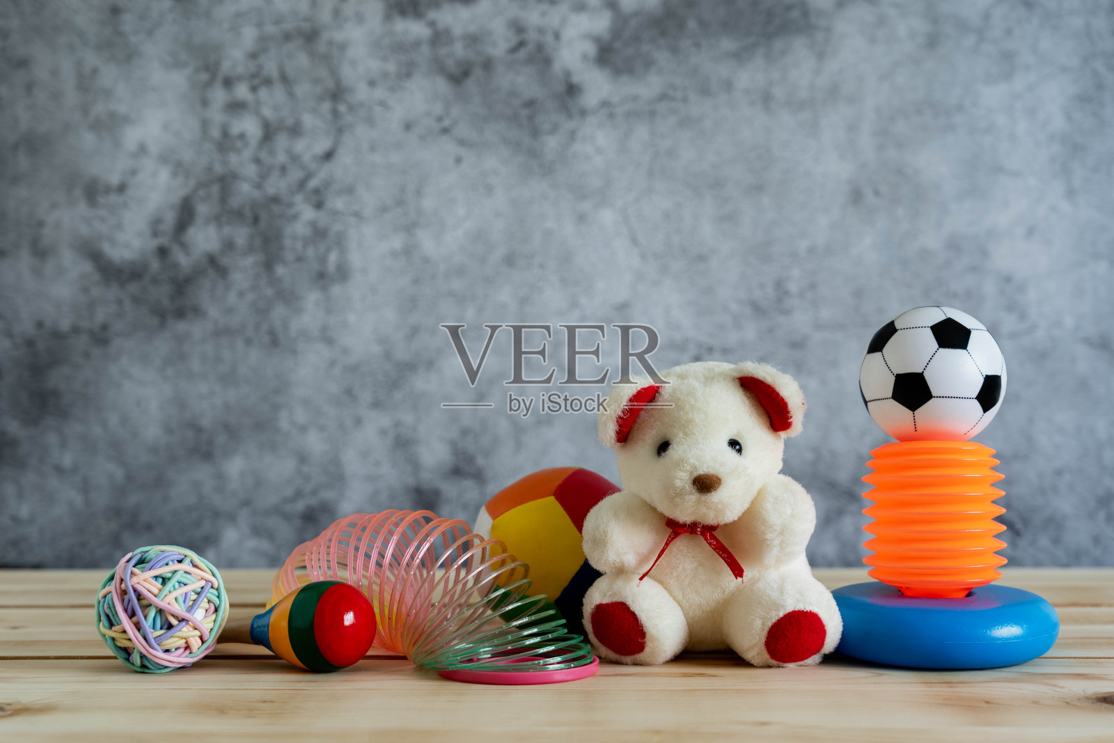 桌子上的物品装饰儿童玩具和学习背景概念。熊娃娃，球，沙球和更多的物品在现代乡村棕色木制和灰色水泥。复制空间的创造性添加文本。照片摄影图片