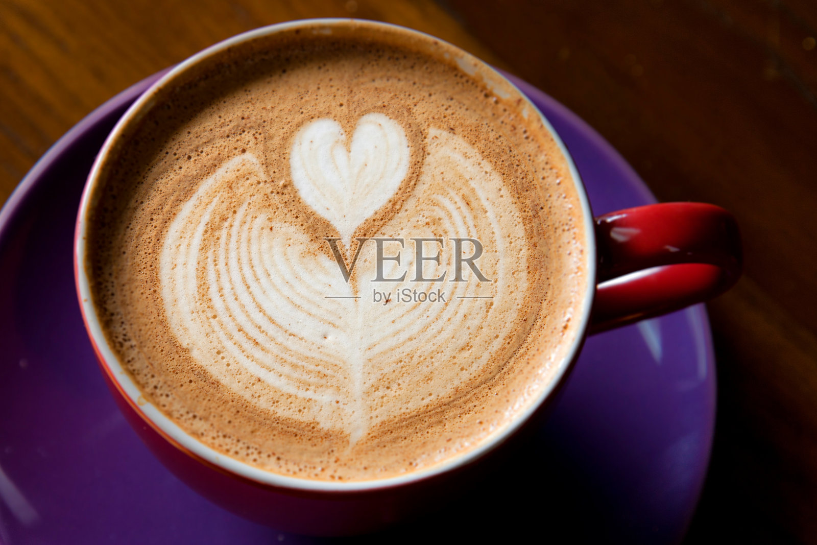 红杯热拿铁咖啡，心形和蕨类泡沫设计照片摄影图片