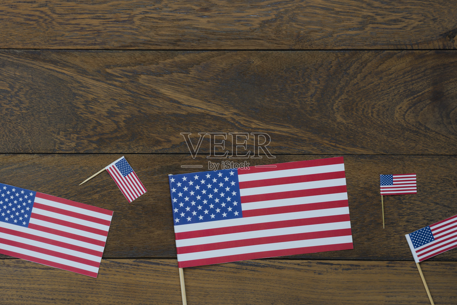 表顶视图4月独立日假期背景概念。美国国旗作为季节标志平躺在现代乡村棕色木制办公桌上。为创意设计文本和内容提供自由空间。照片摄影图片