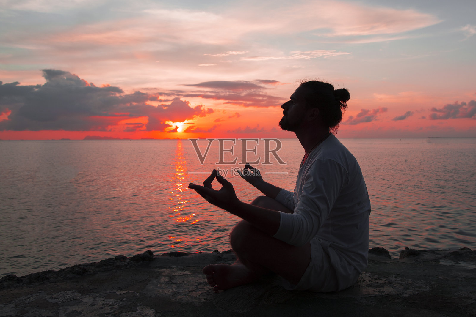 瑜伽场景剪影男人在日落。海洋。照片摄影图片