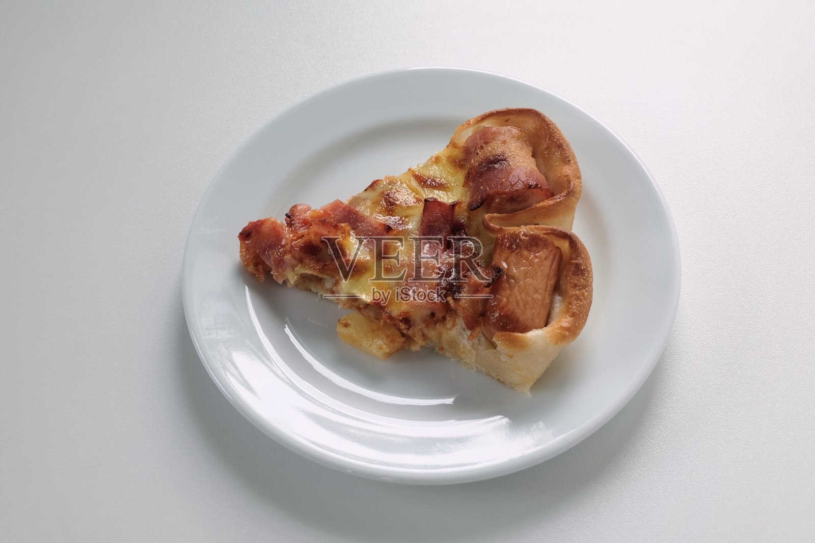 一块披萨放在一个白色的盘子里照片摄影图片