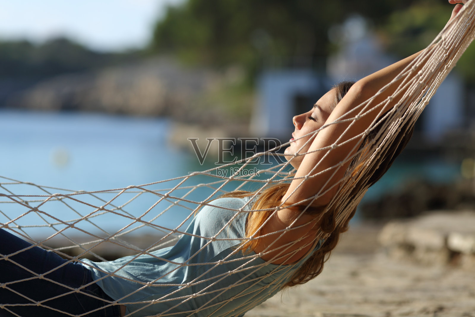 放松的女人在沙滩上的吊床上休息照片摄影图片