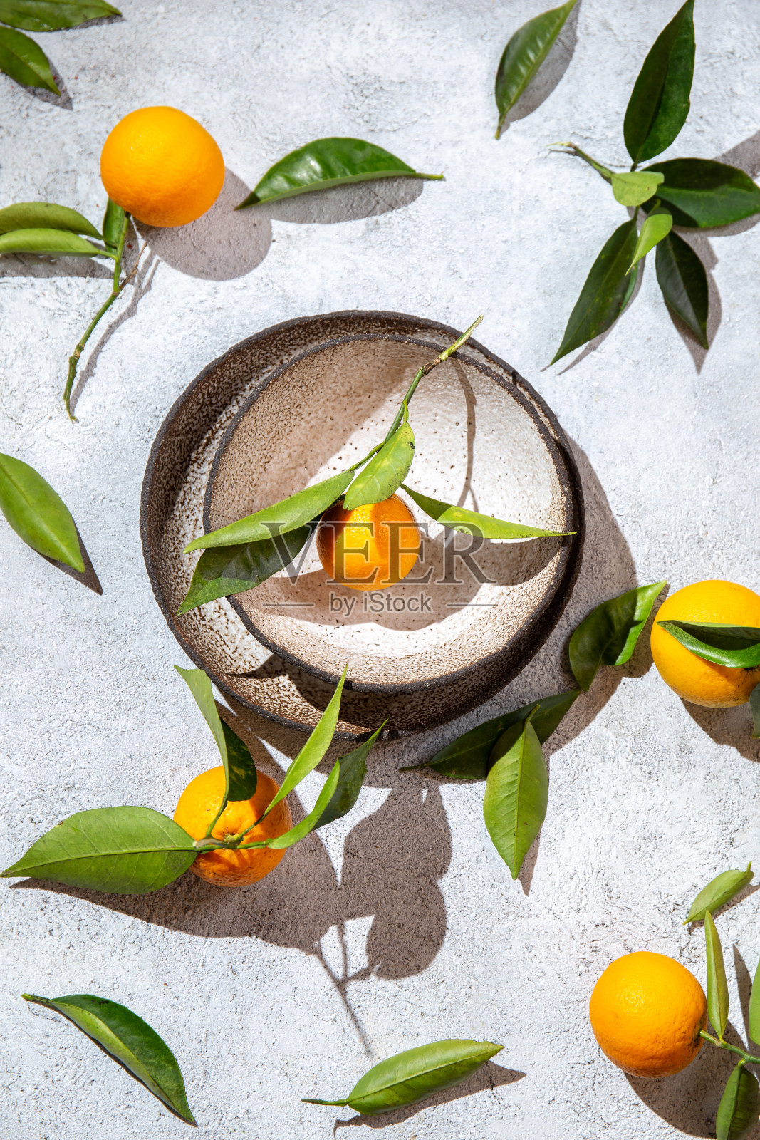 整个橙子和橙色的树叶在白色的背景周围的盘子。俯视图，平躺，夏季和健康的概念照片摄影图片