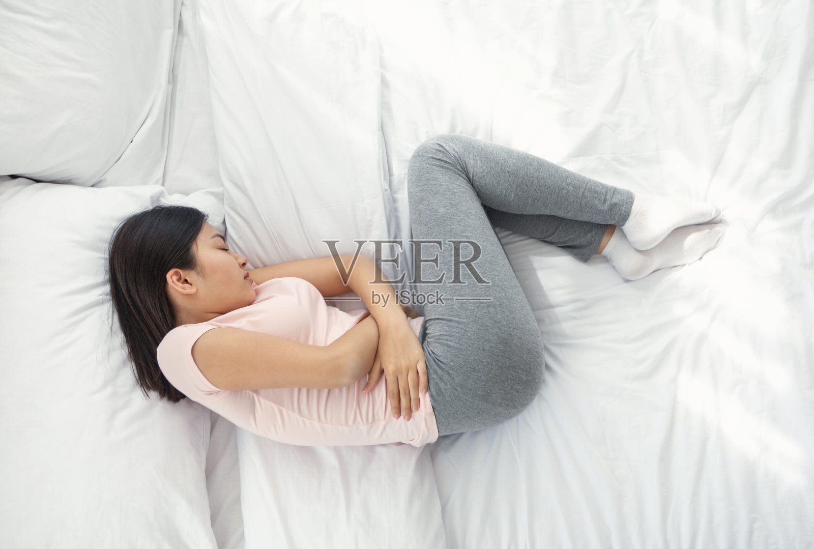 亚洲妇女在家里睡觉时腹痛，上图照片摄影图片