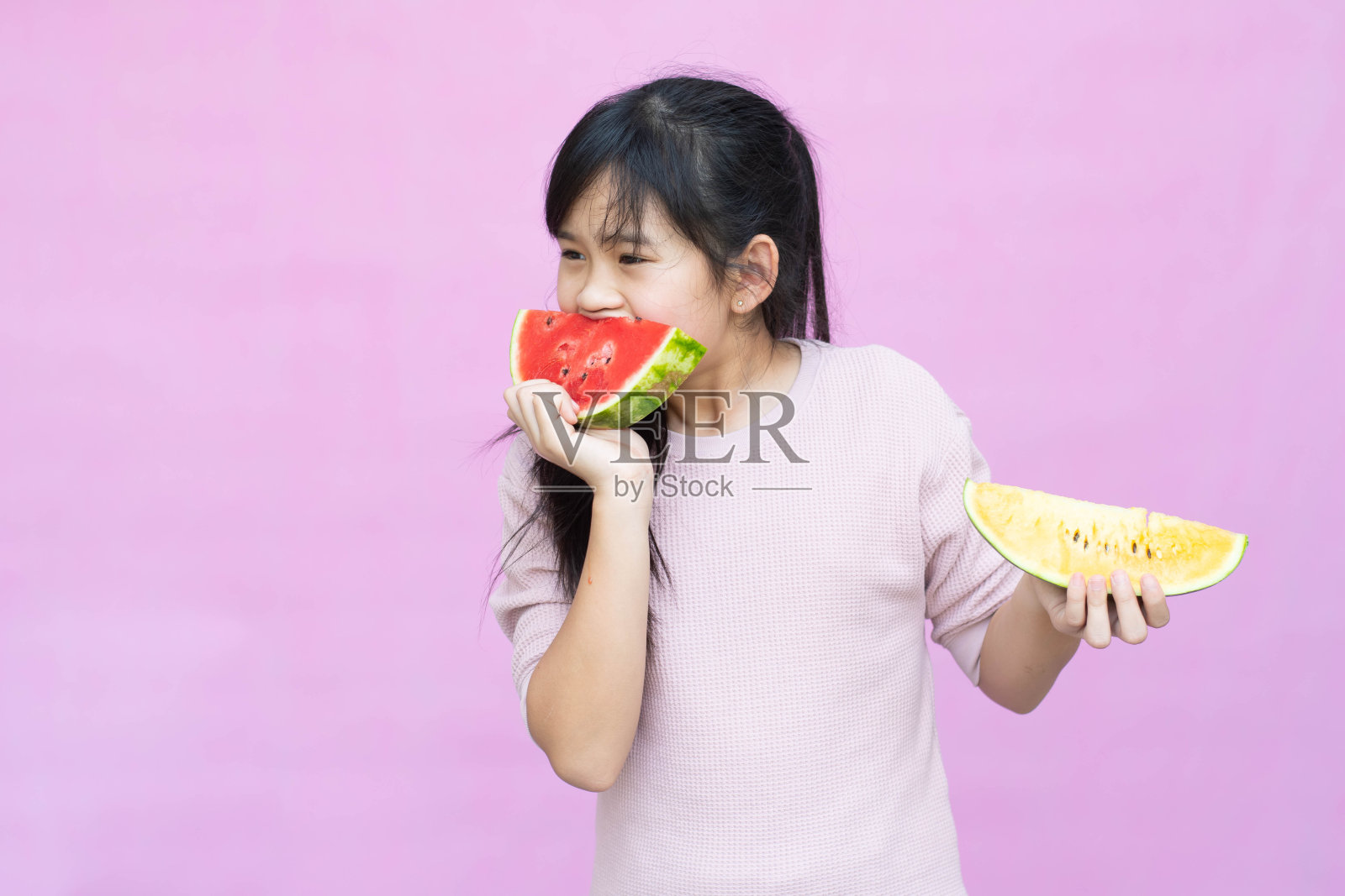 一个小女孩和西瓜的肖像，夏天孤立在粉红色的背景。照片摄影图片