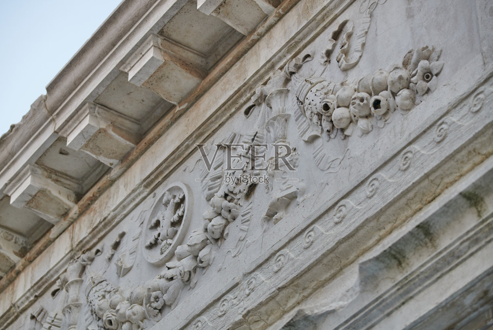 威尼斯历史建筑的石头檐口细节，装饰着花环，水果，丝带和图标照片摄影图片