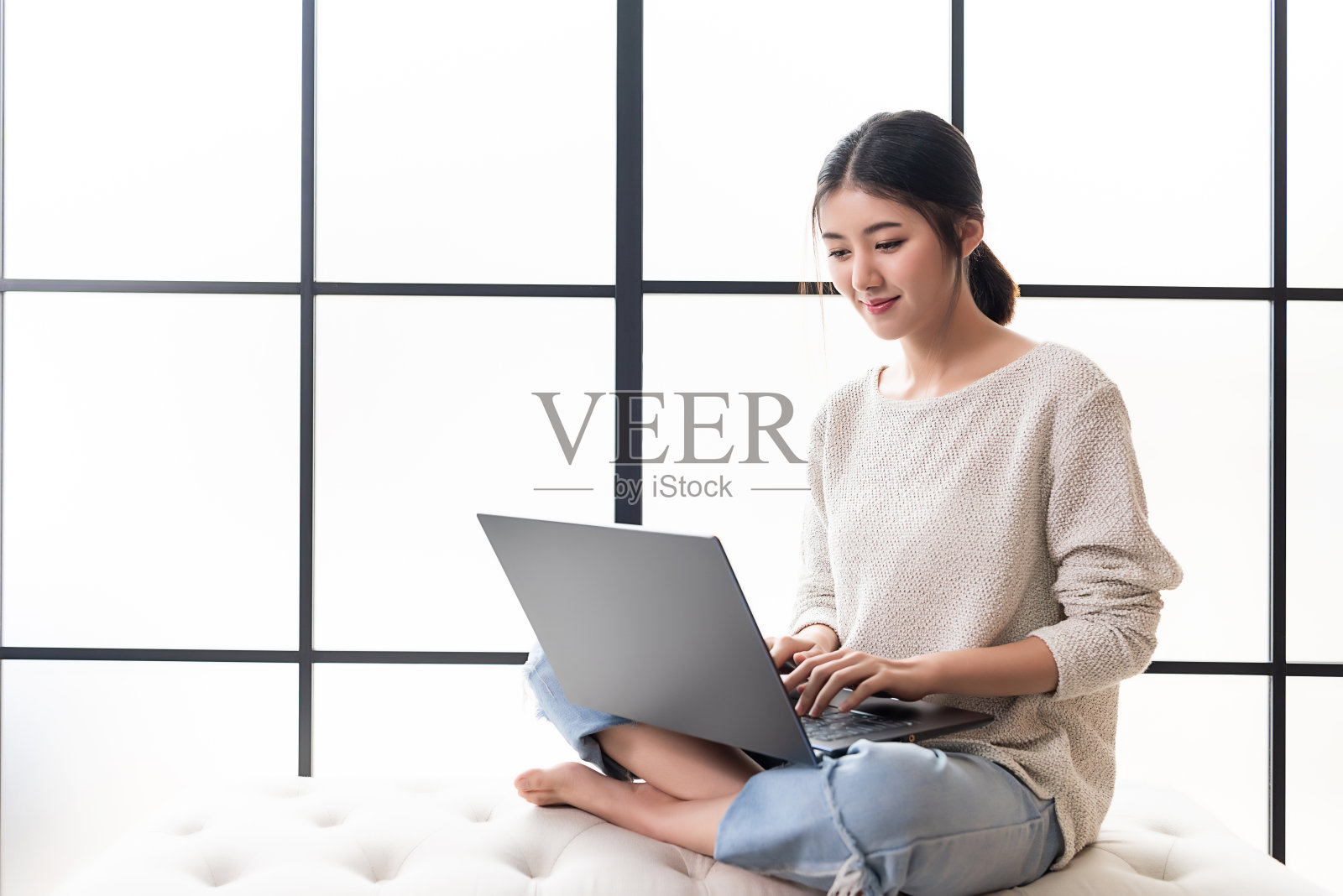 一个亚洲职业妇女正在她的电脑上工作。在家轻松工作。照片摄影图片