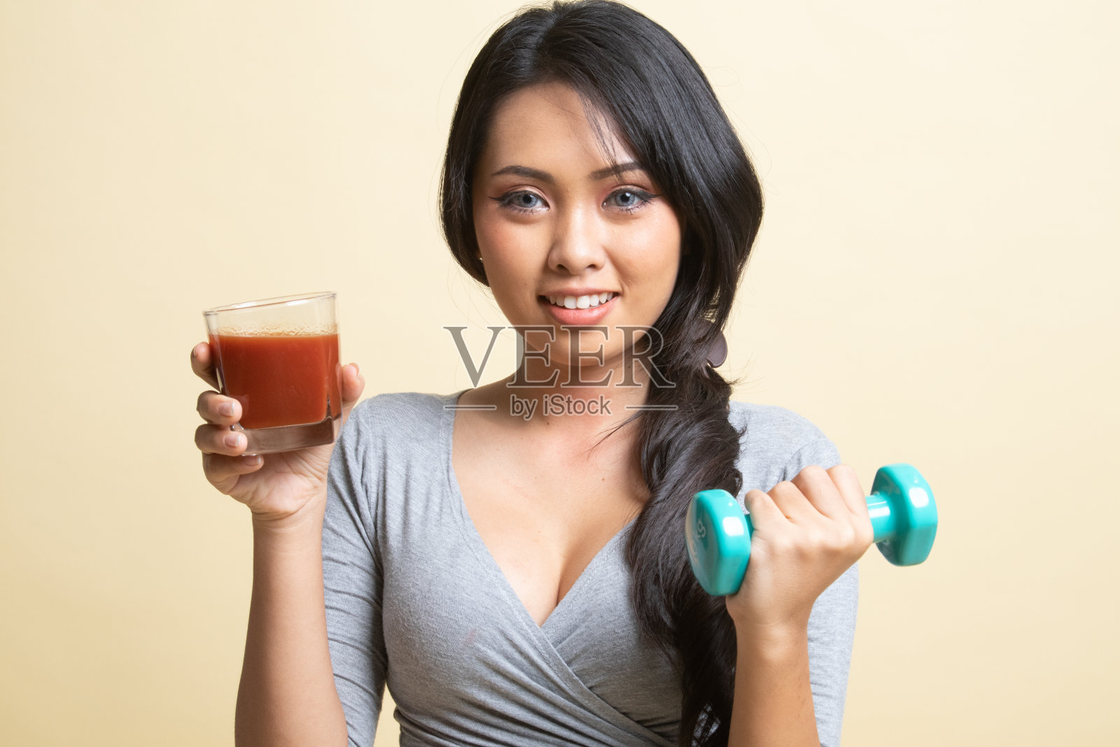 健康的亚洲女人，哑铃和番茄汁。照片摄影图片