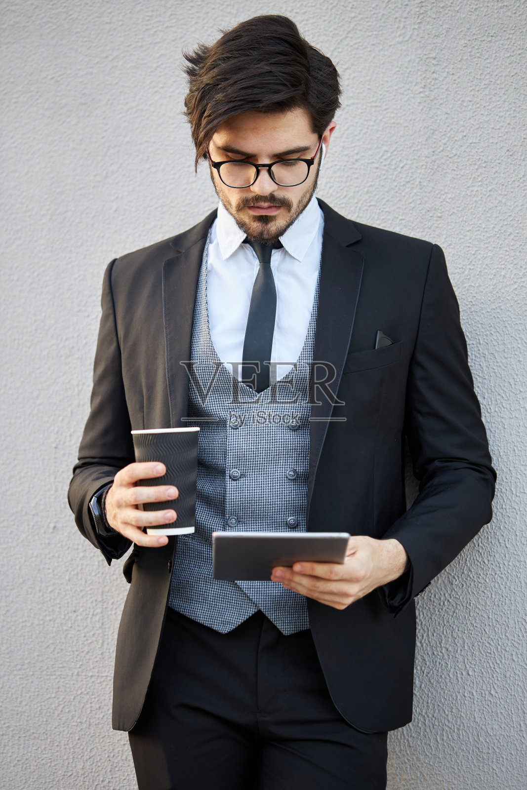 年轻的商人穿着经典套装在外面使用平板电脑照片摄影图片