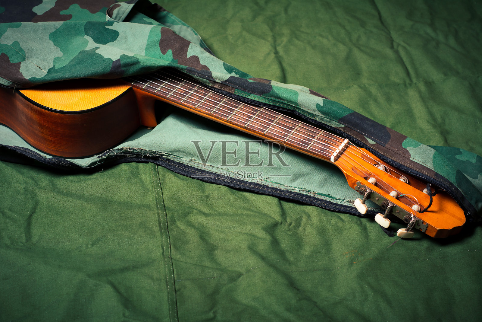 原声吉他在一个军用图案的袋子在一个军队帐篷照片摄影图片