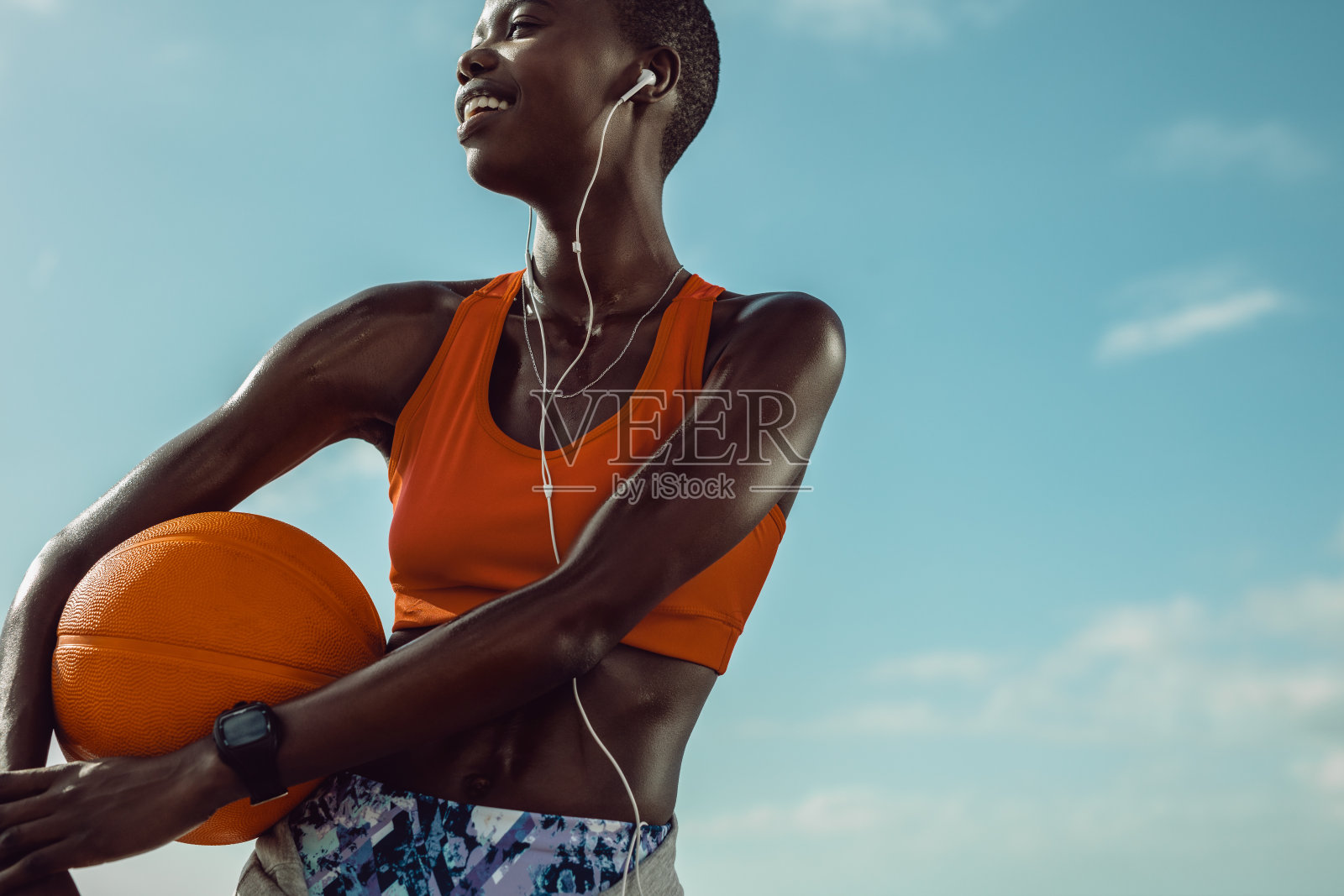 举着篮球站在户外的女运动员照片摄影图片