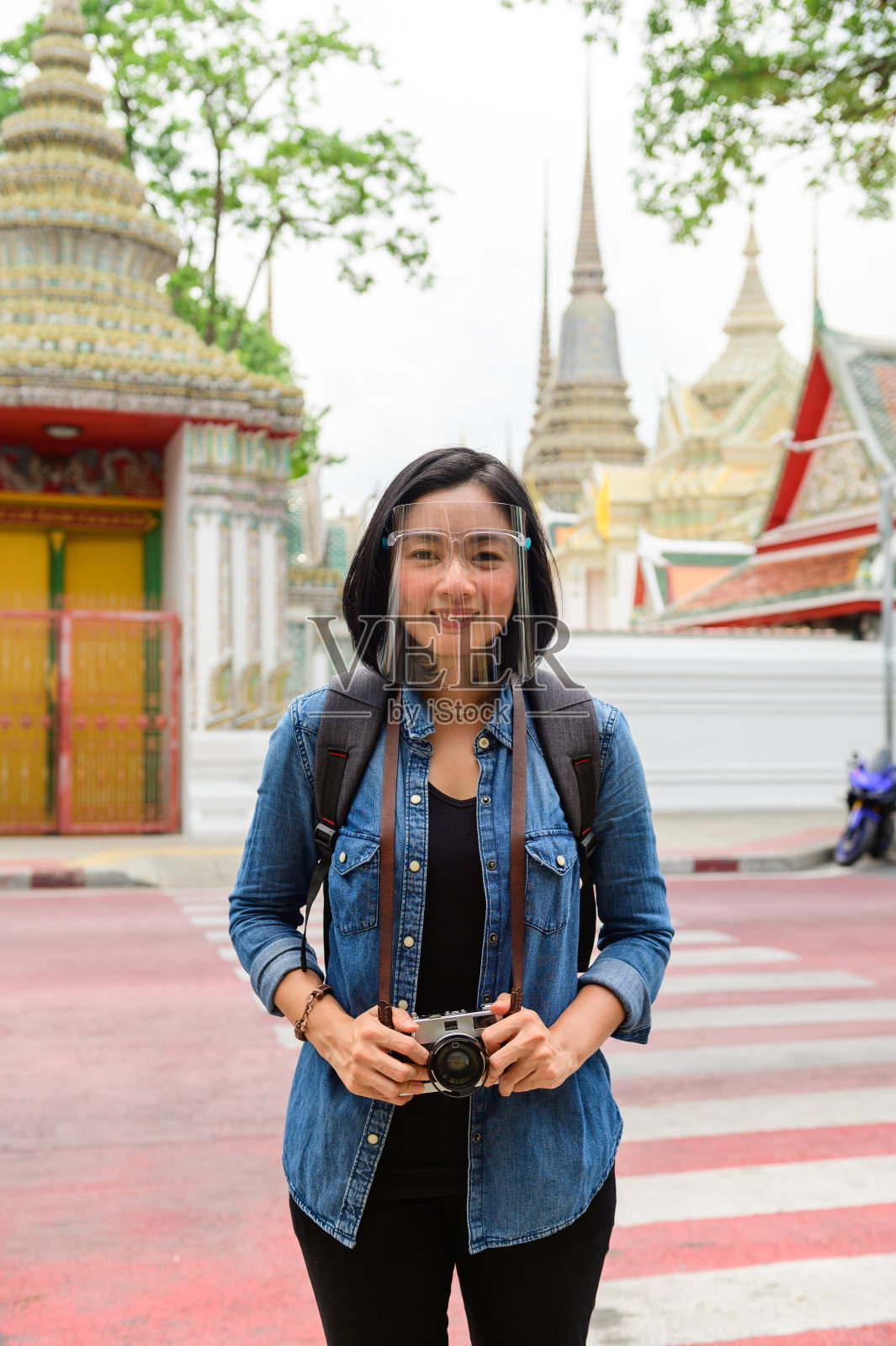 新冠肺炎大流行后的生活亚洲妇女在曼谷卧佛寺度假带着相机照片摄影图片