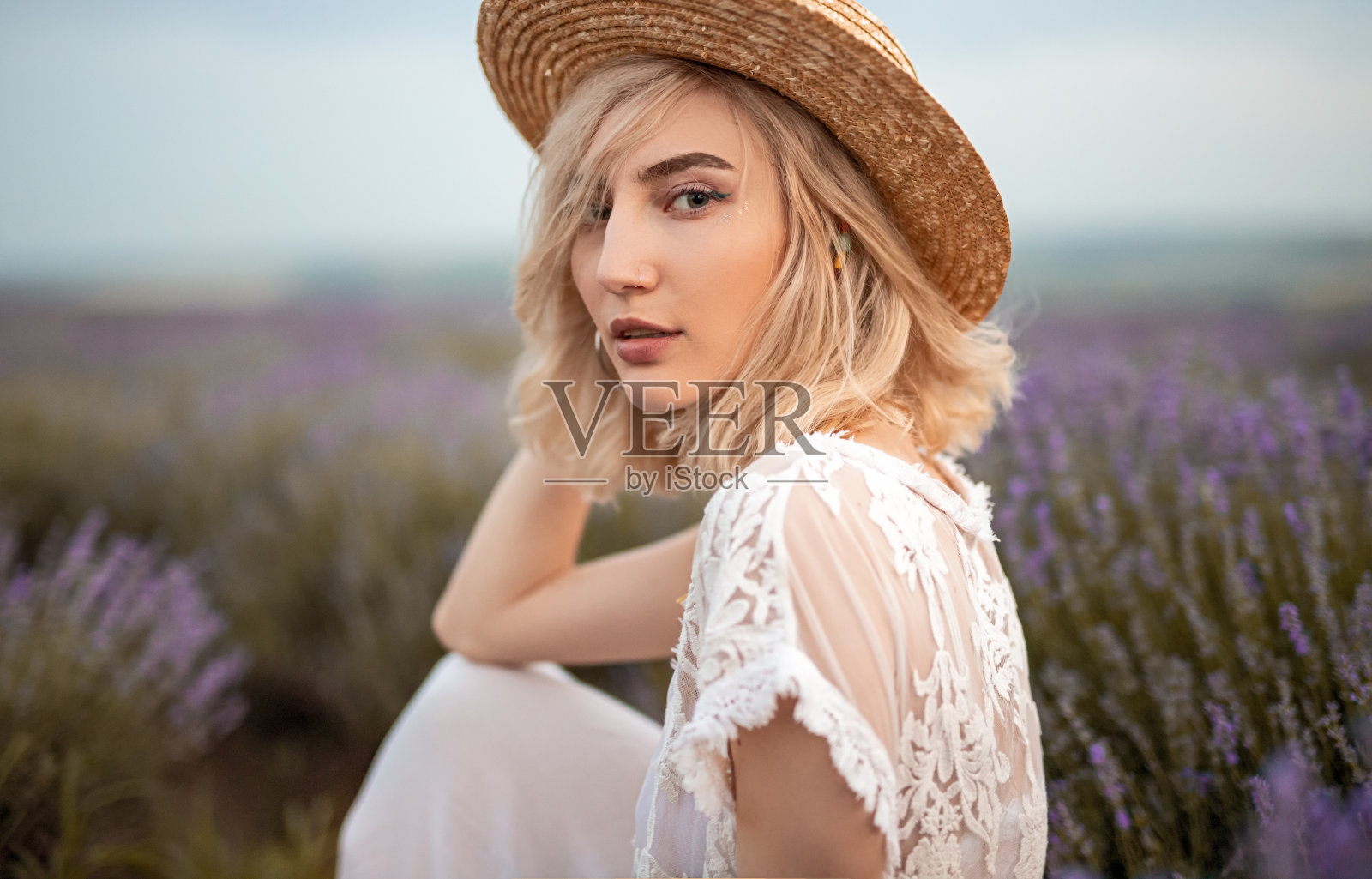 美丽性感的女人在紫罗兰野花的田野里照片摄影图片