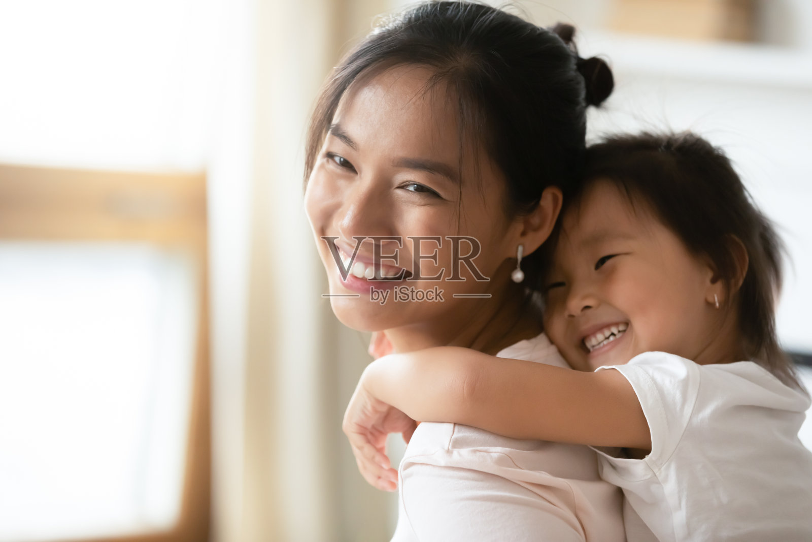 可爱的学前班亚洲小孩的女儿抱着妈妈。照片摄影图片