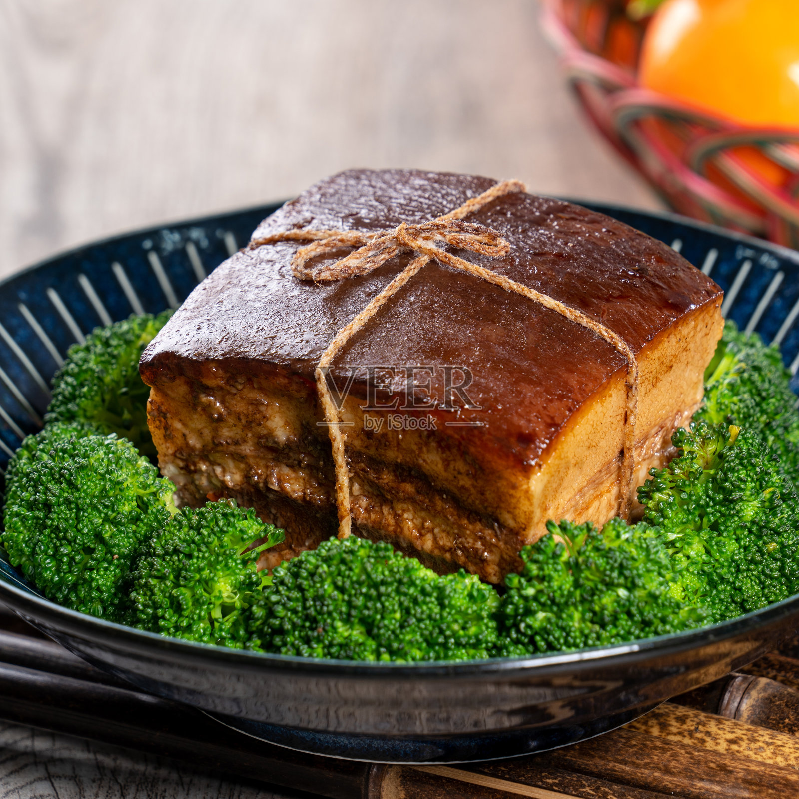 东坡肉(东坡肉)在一个漂亮的蓝色盘子与绿色的花椰菜蔬菜，传统的节日食品，中国新年美食大餐，特写。照片摄影图片