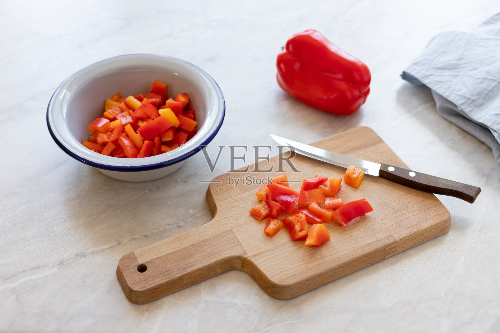 用刀把红甜椒剁碎，放在木砧板上照片摄影图片