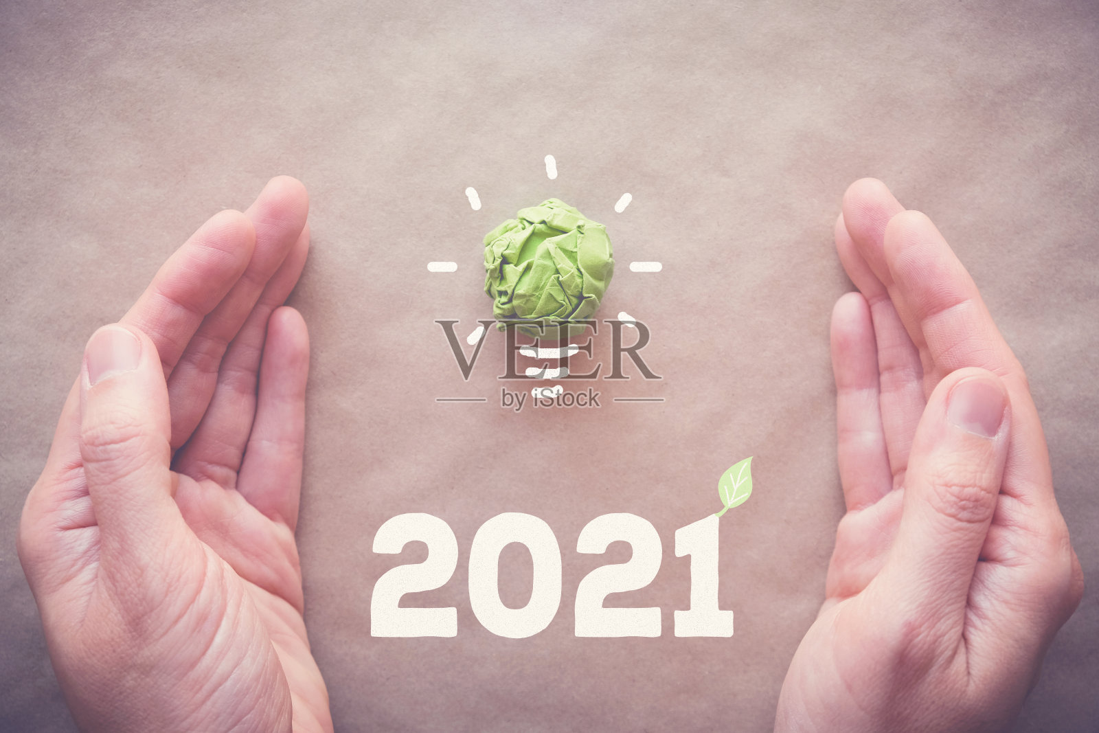 手与2021绿色纸灯泡，新年生态和可持续的生活决议概念照片摄影图片