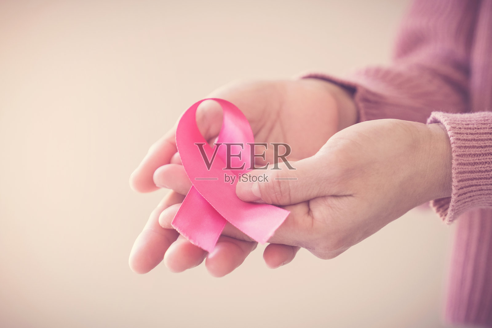 妇女穿粉红上衣和粉红丝带，乳腺癌意识，十月粉红，世界癌症日的概念照片摄影图片