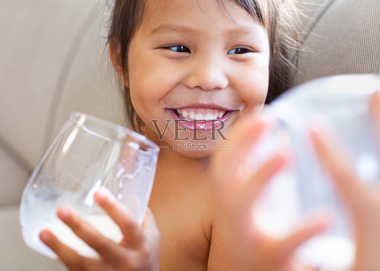 快乐的孩子喝着一杯牛奶。日记。照片摄影图片
